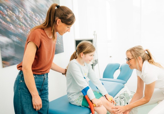 Fr. Dr. Endele untersucht Bein eines Kindes mit Krücken