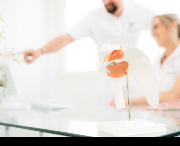 Modell mit Ärzteteam unscharf im Hintergrund