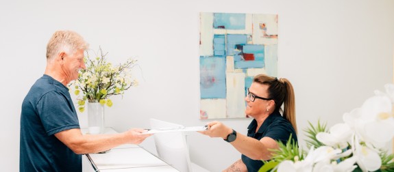 Patient gibt ausgefüllte Daten an der Anmeldung zurück