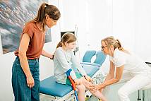 Fr. Dr. Endele untersucht Bein eines Kindes mit Krücken