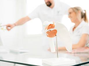 Modell mit Ärzteteam unscharf im Hintergrund